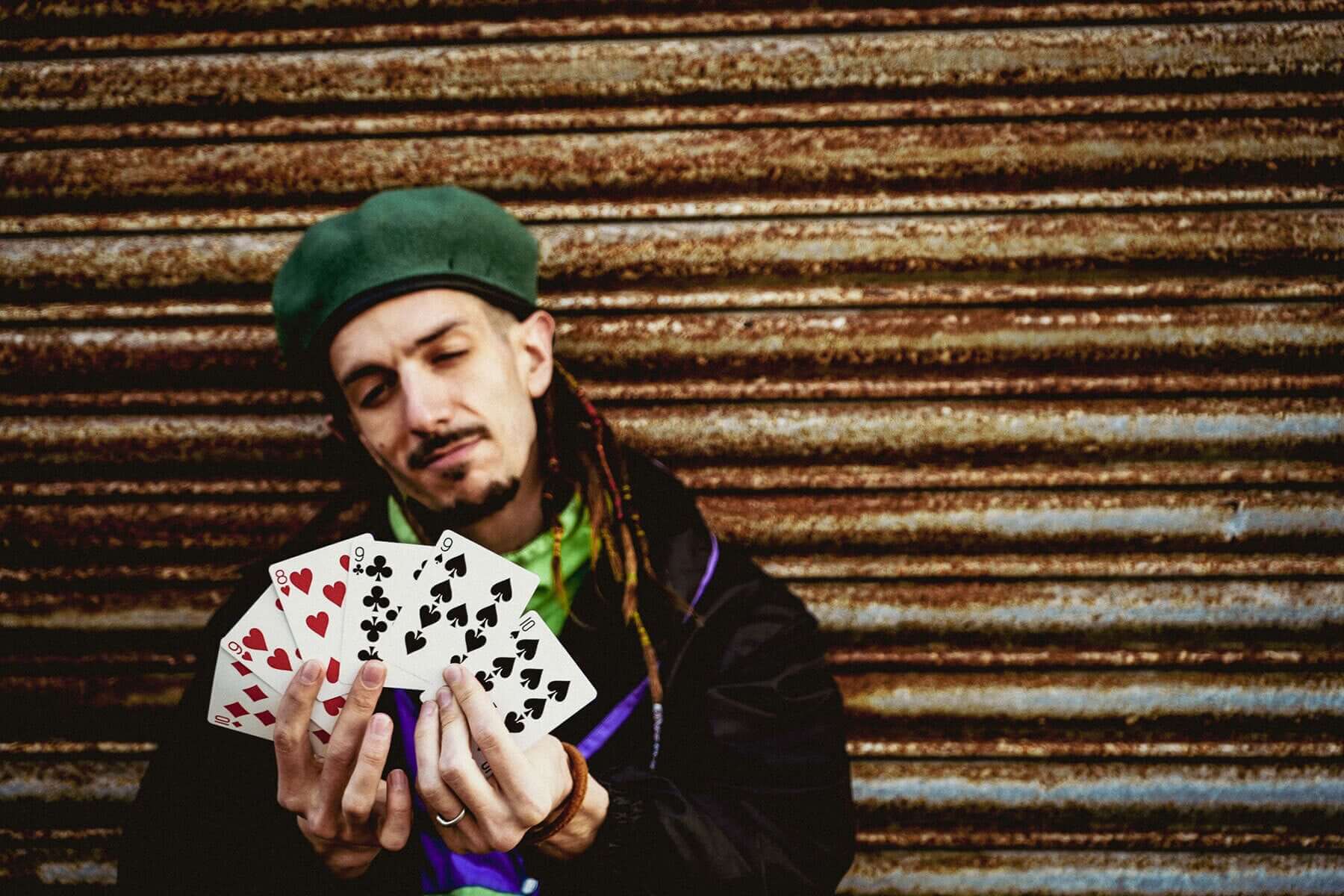 A magician confidently performs H2O, showcasing a deck of cards with a relaxed demeanor, embodying the magic trick experience.
