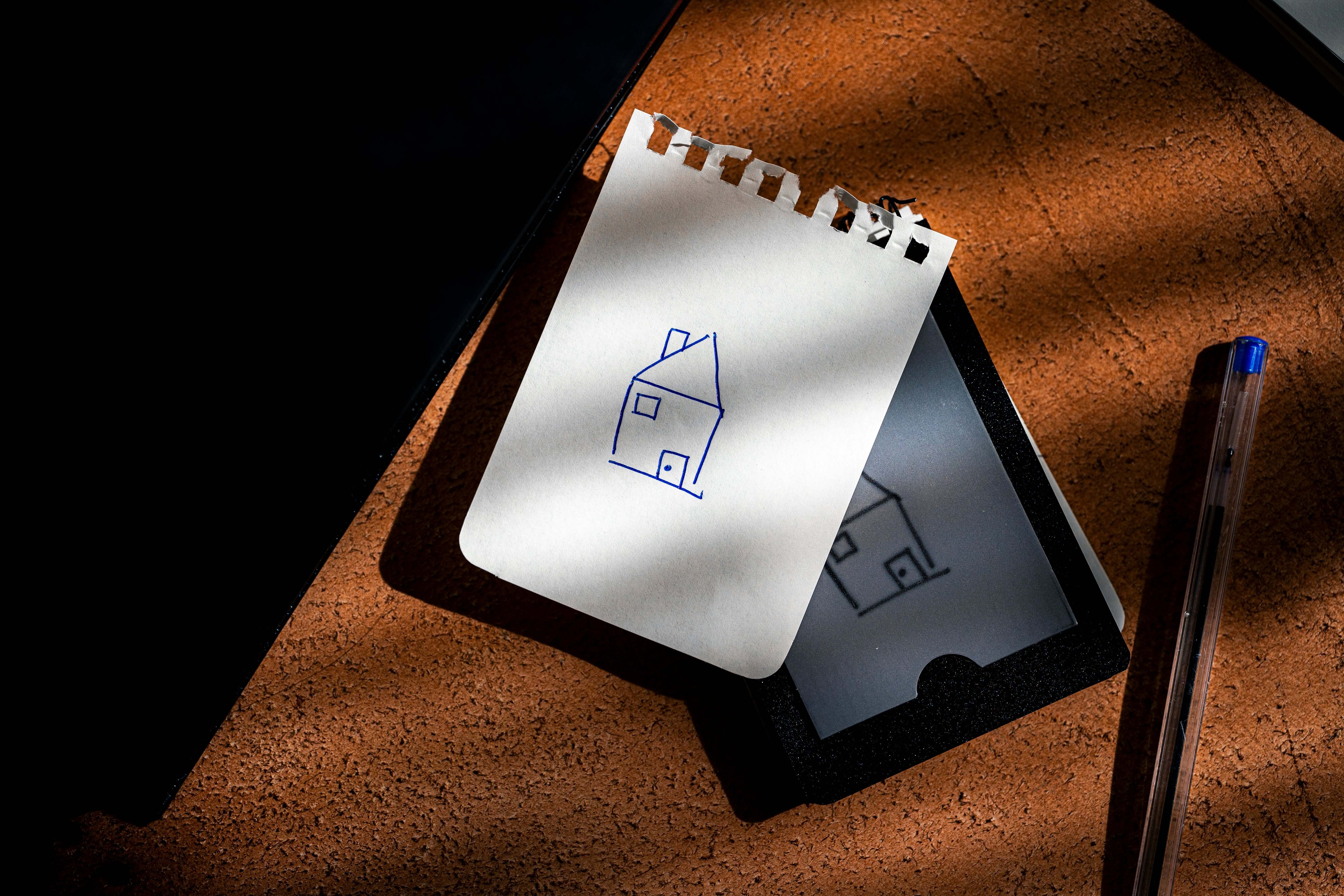 REPLICA: Pocket-size Impression Pad with a sketched house on a notepad, symbolizing old-school magic.