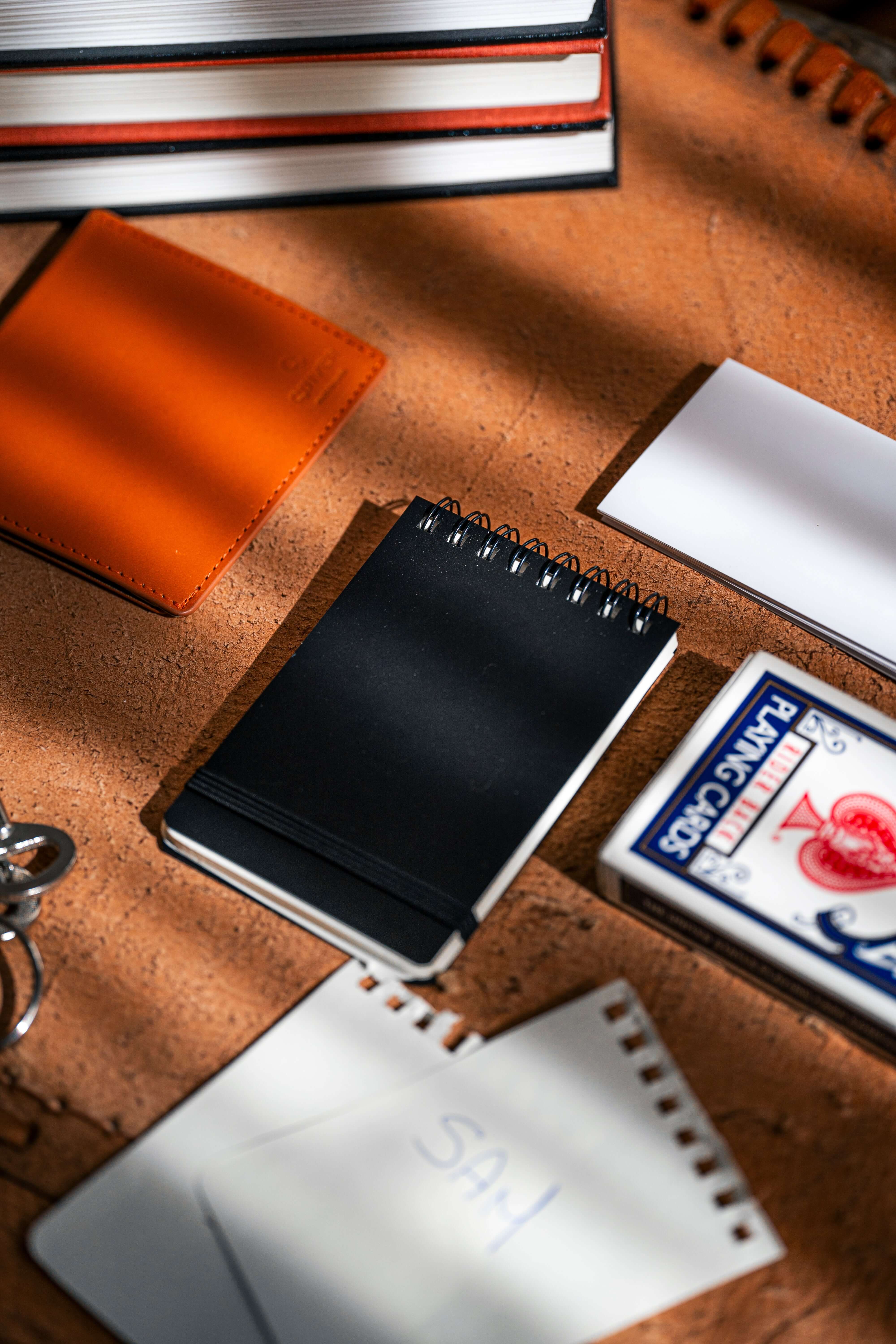 Flat lay of various notebooks and playing cards highlighting the REPLICA: Pocket-size Impression Pad.