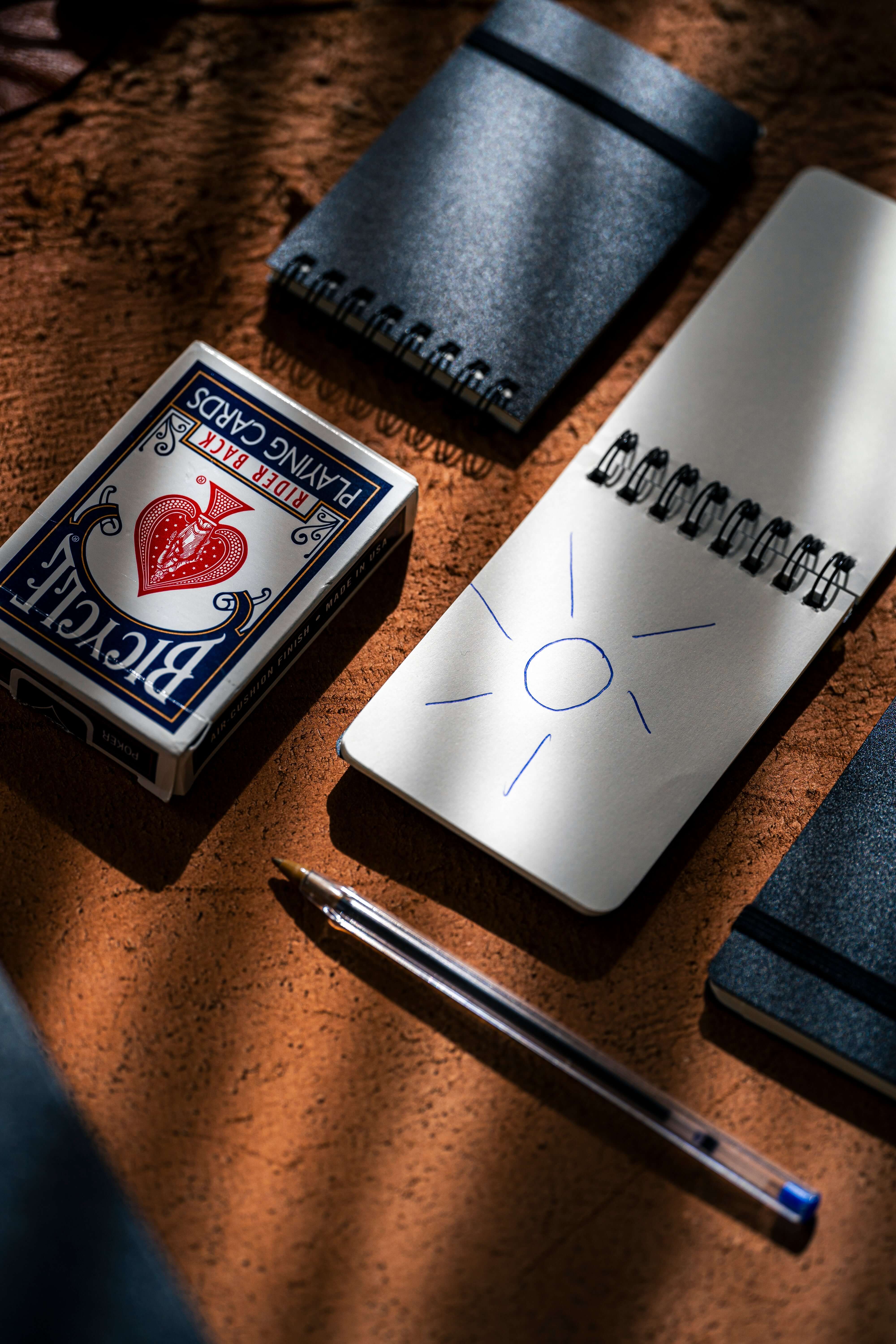 REPLICA: Pocket-size Impression Pad alongside playing cards and a pen on a textured surface.